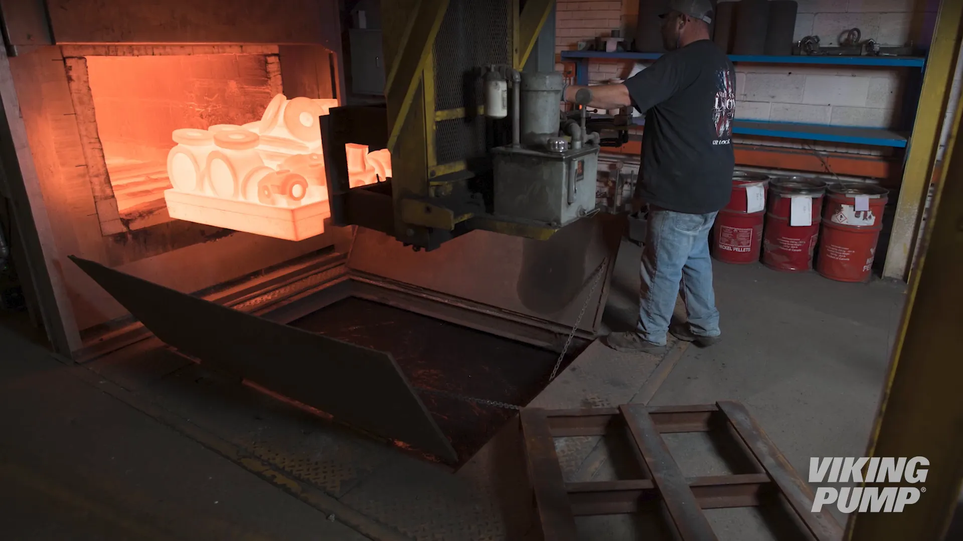 Parts being carefully placed in an oven for heat treatment.