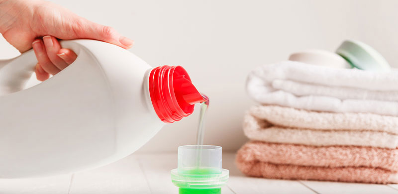 detergent gel being poured into a cup for laundry
